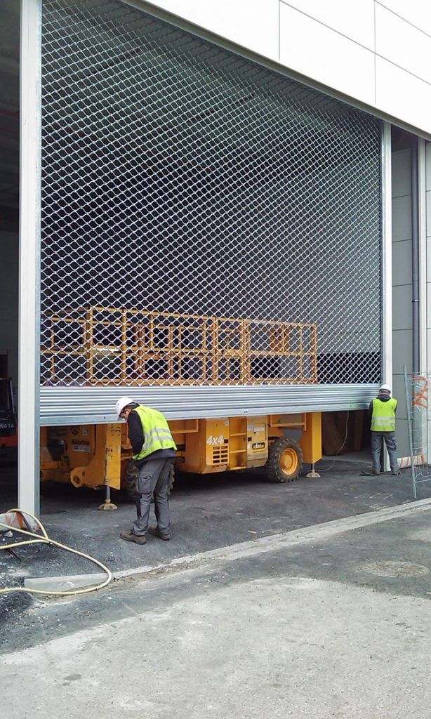 Deux homme ouvre une grille métallique