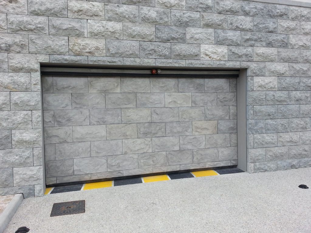 Mur de pierres et porte de garage en pierre