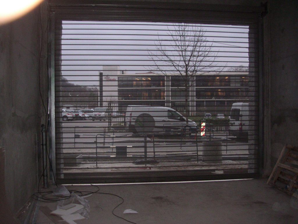 Vue sur une route à travers une grille métallique