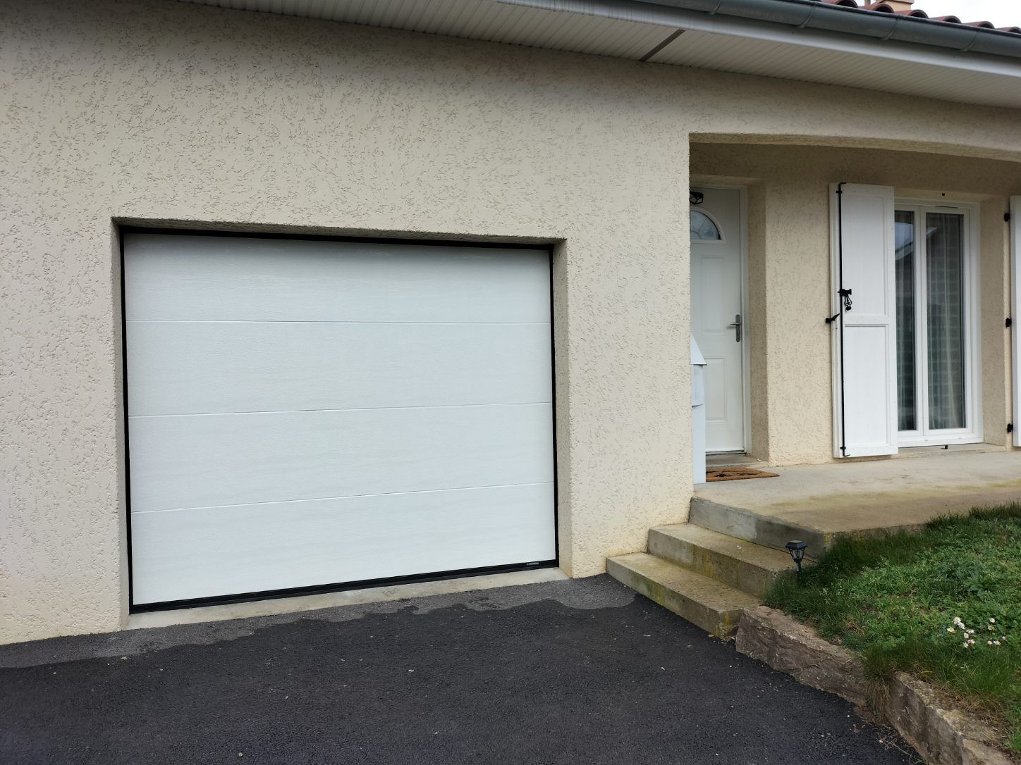 Façade de maison avec porte de garage et porte d'entrée