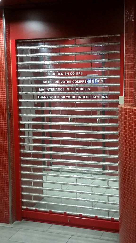 Un rideau métallique et un mur rouge