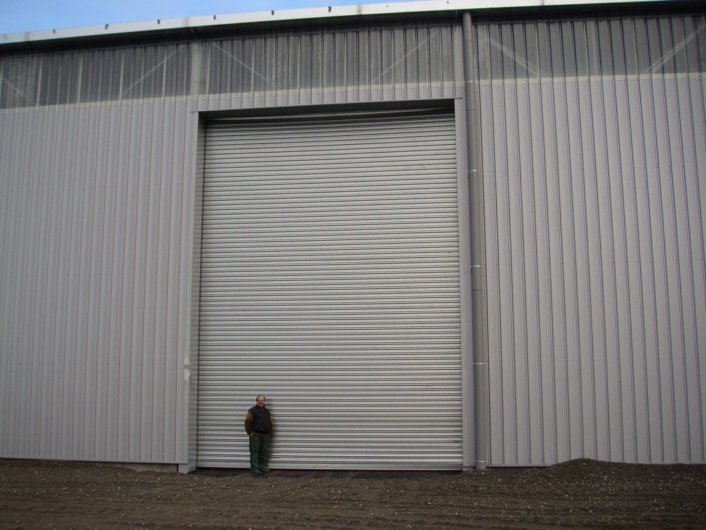 Un homme devant un rideau métallique