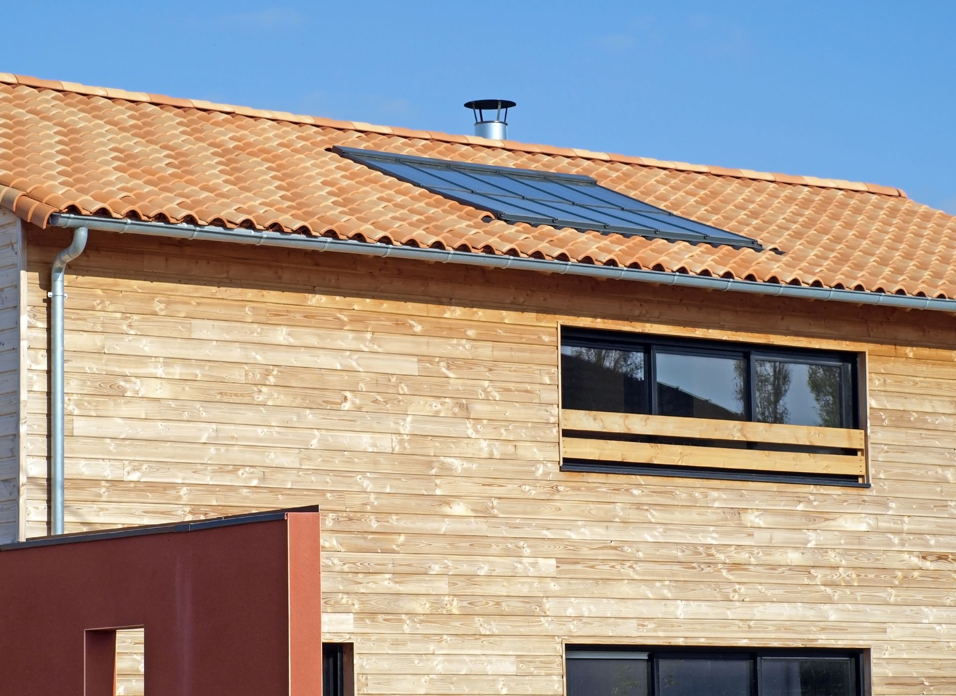 Maison avec bardage en bois et panneaux solaires