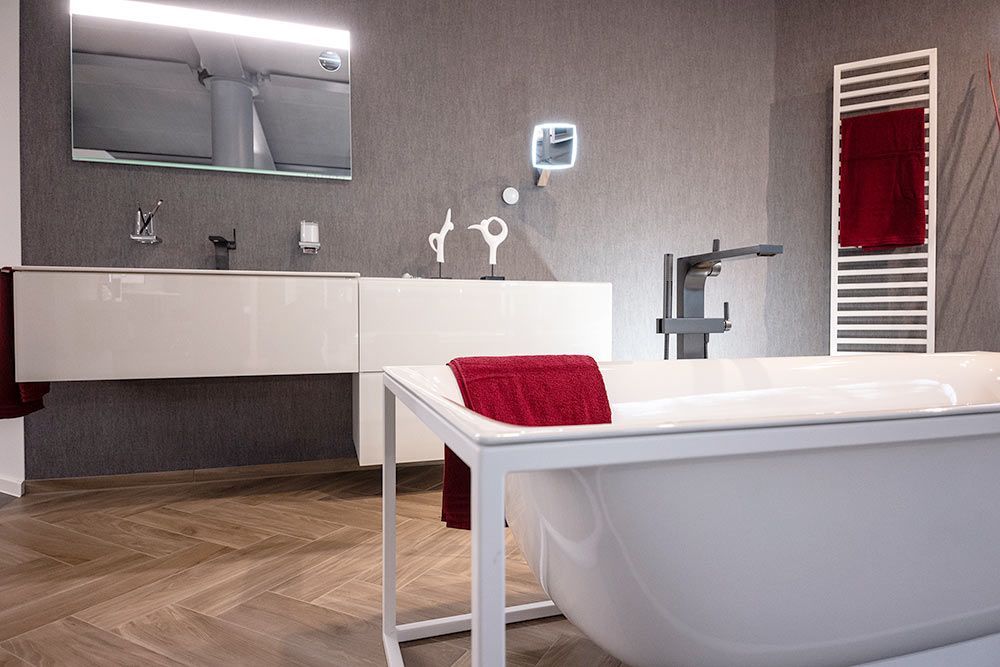 Ein Badezimmer mit Badewanne, Waschbecken, Spiegel und Handtuchhalter.