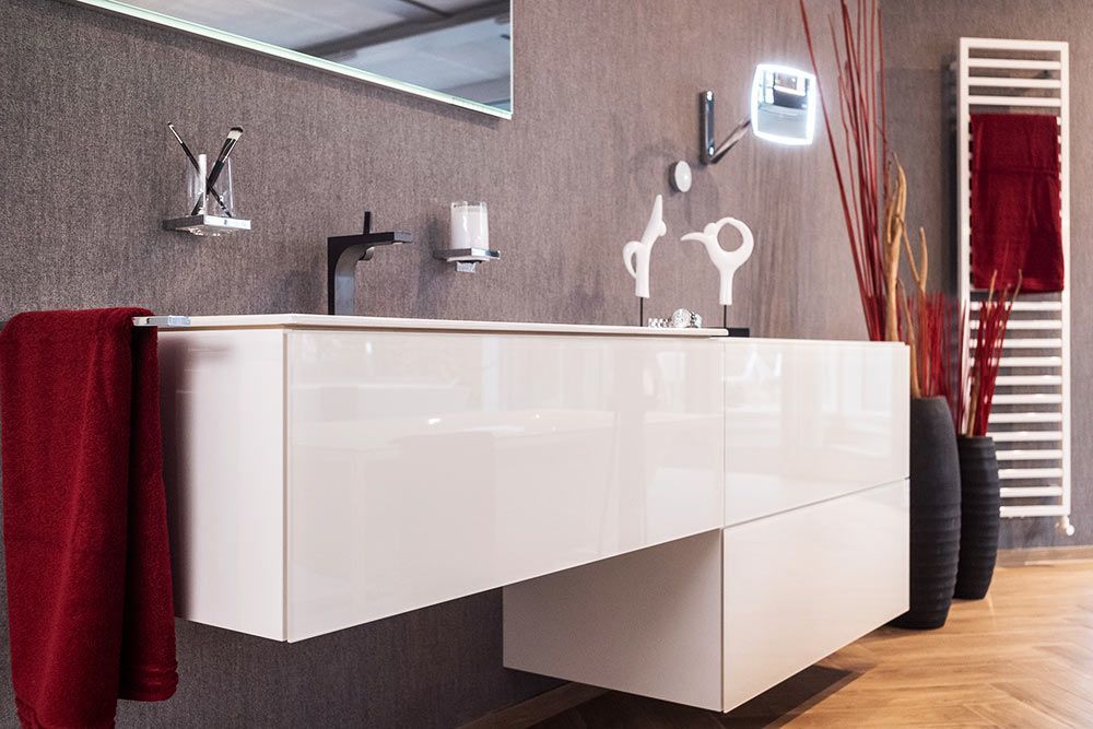 Ein Badezimmer mit Waschbecken, Spiegel und Handtuchhalter