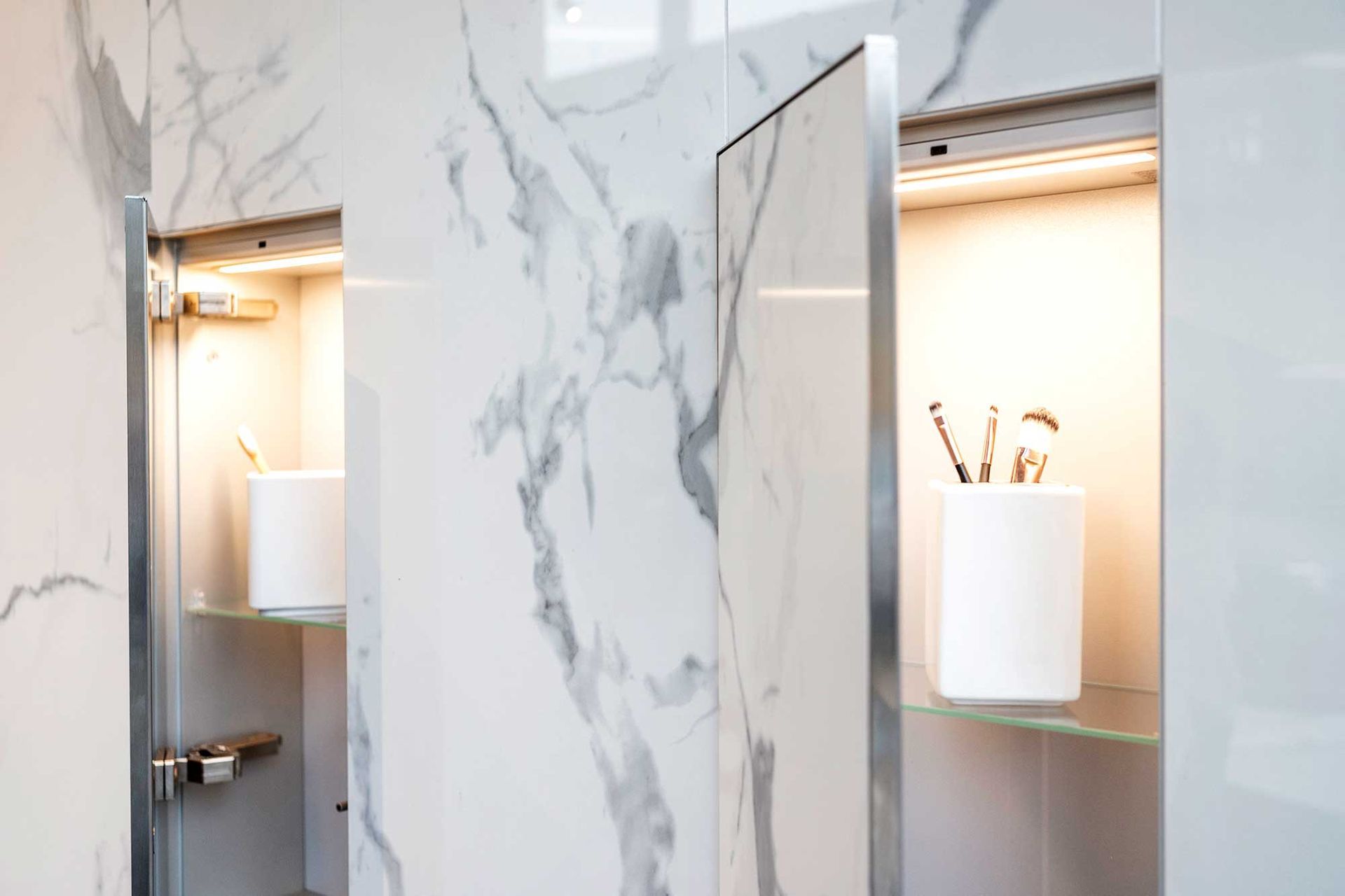 Ein Badezimmer mit einer Marmorwand und einem Regal mit einer Zahnbürste darauf.