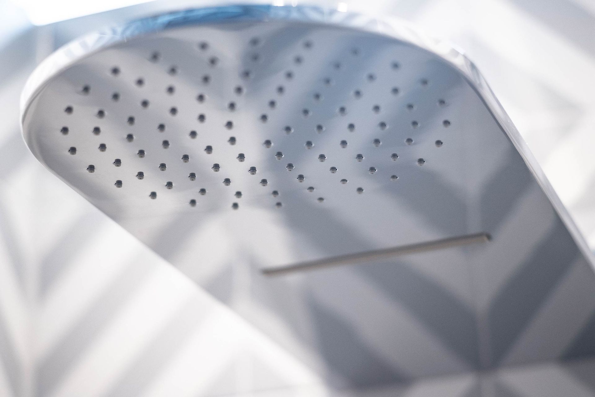 Eine Nahaufnahme eines Duschkopfs mit Löchern darin.