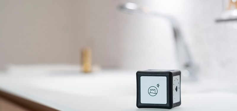 Ein schwarz-weißer Würfel steht auf einer Ablage in einem Badezimmer.