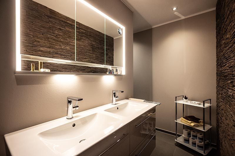 Ein Badezimmer mit zwei Waschbecken und einem großen Spiegel.