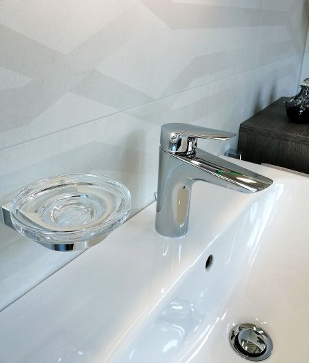 Ein Waschbecken mit verchromtem Wasserhahn und Seifenschale