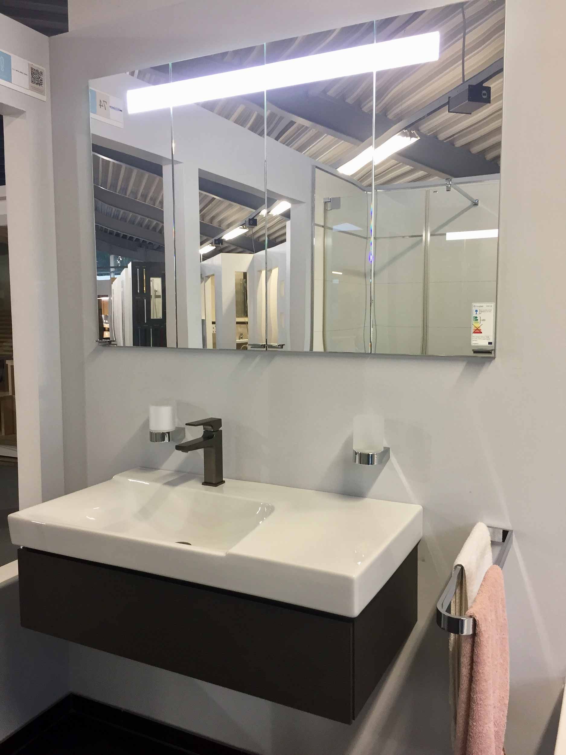 Ein Badezimmer mit Waschbecken, Spiegel und Handtuchhalter.