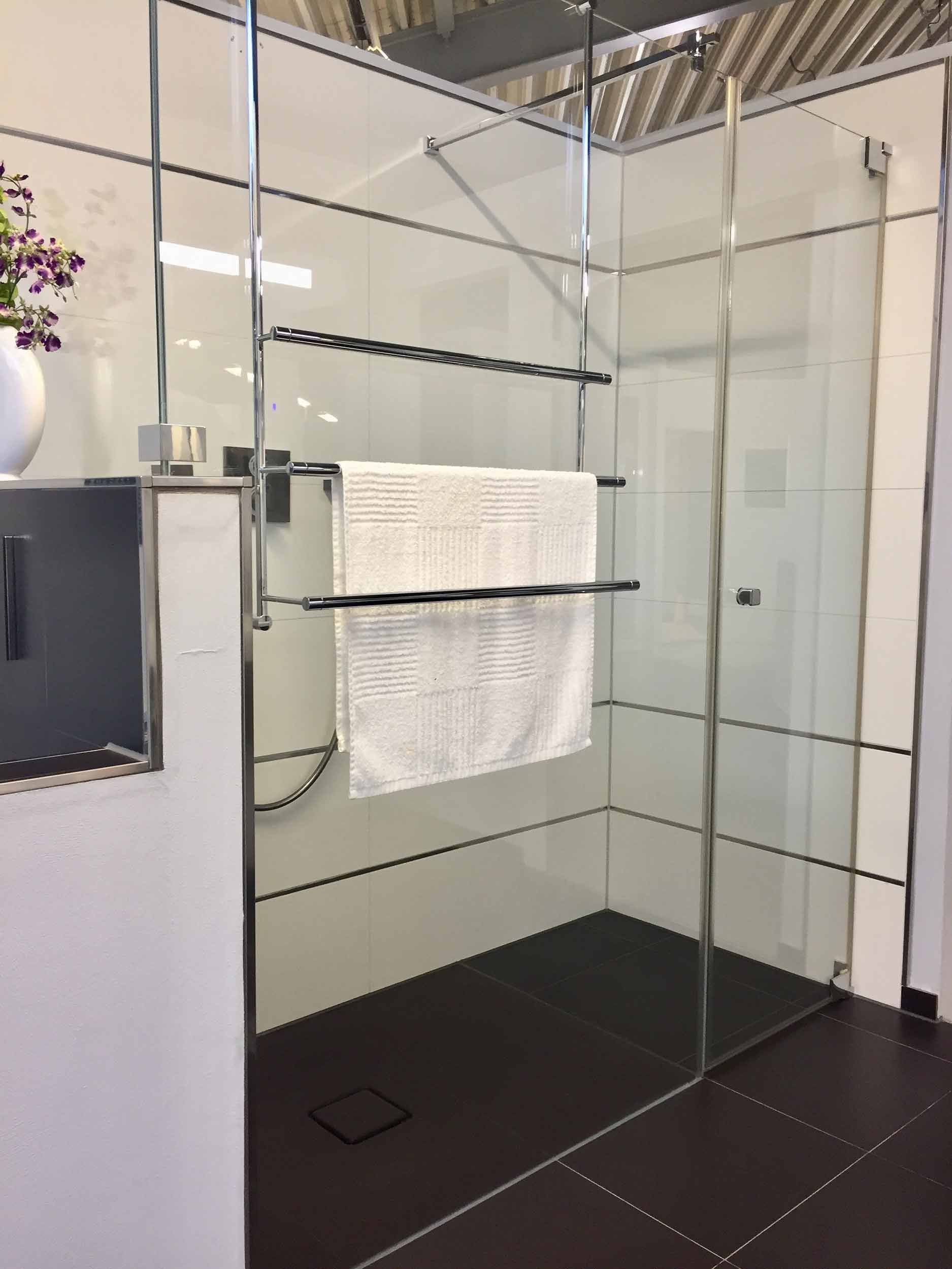 Ein Badezimmer mit ebenerdiger Dusche und Handtuchhalter.