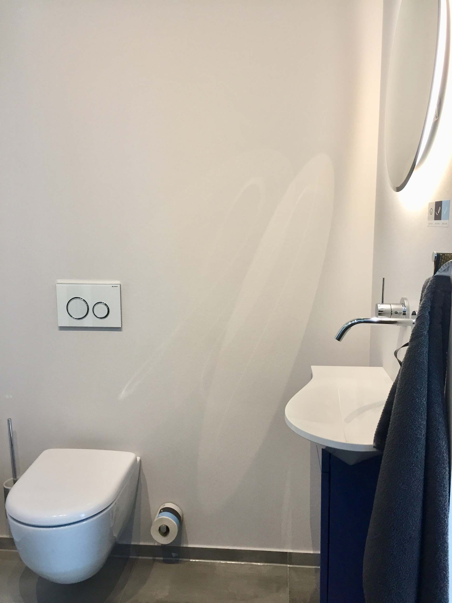 Ein Badezimmer mit Toilette, Waschbecken und Spiegel.