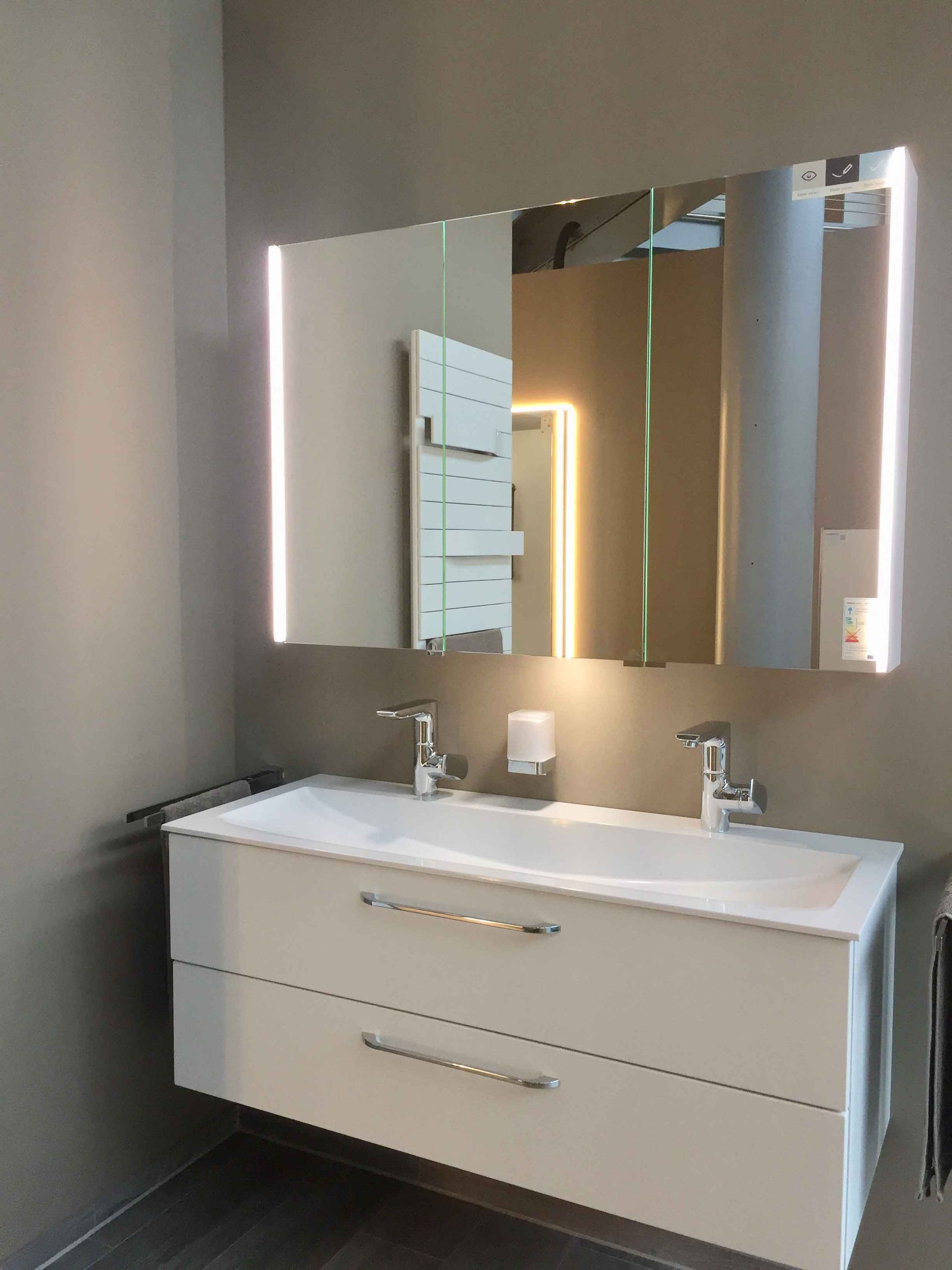 Ein Badezimmer mit Waschbecken, Spiegel und Handtuchhalter.