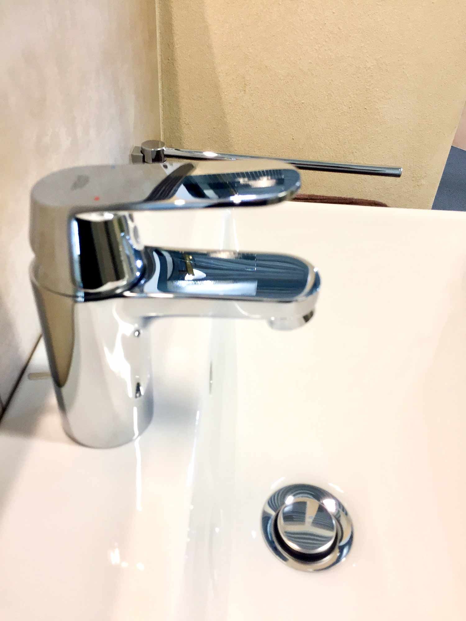 Ein Waschbecken mit verchromtem Wasserhahn und Abfluss