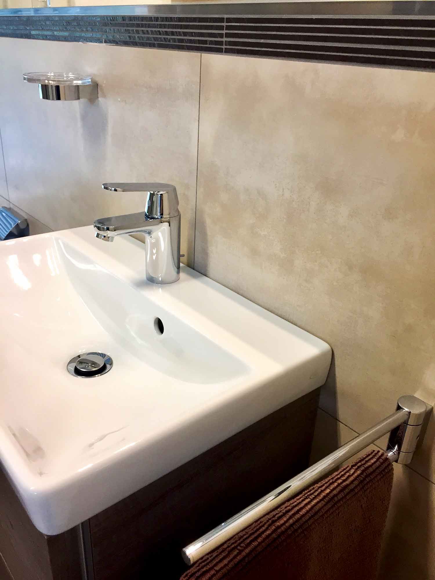 Ein Waschbecken mit Wasserhahn und Handtuchhalter.