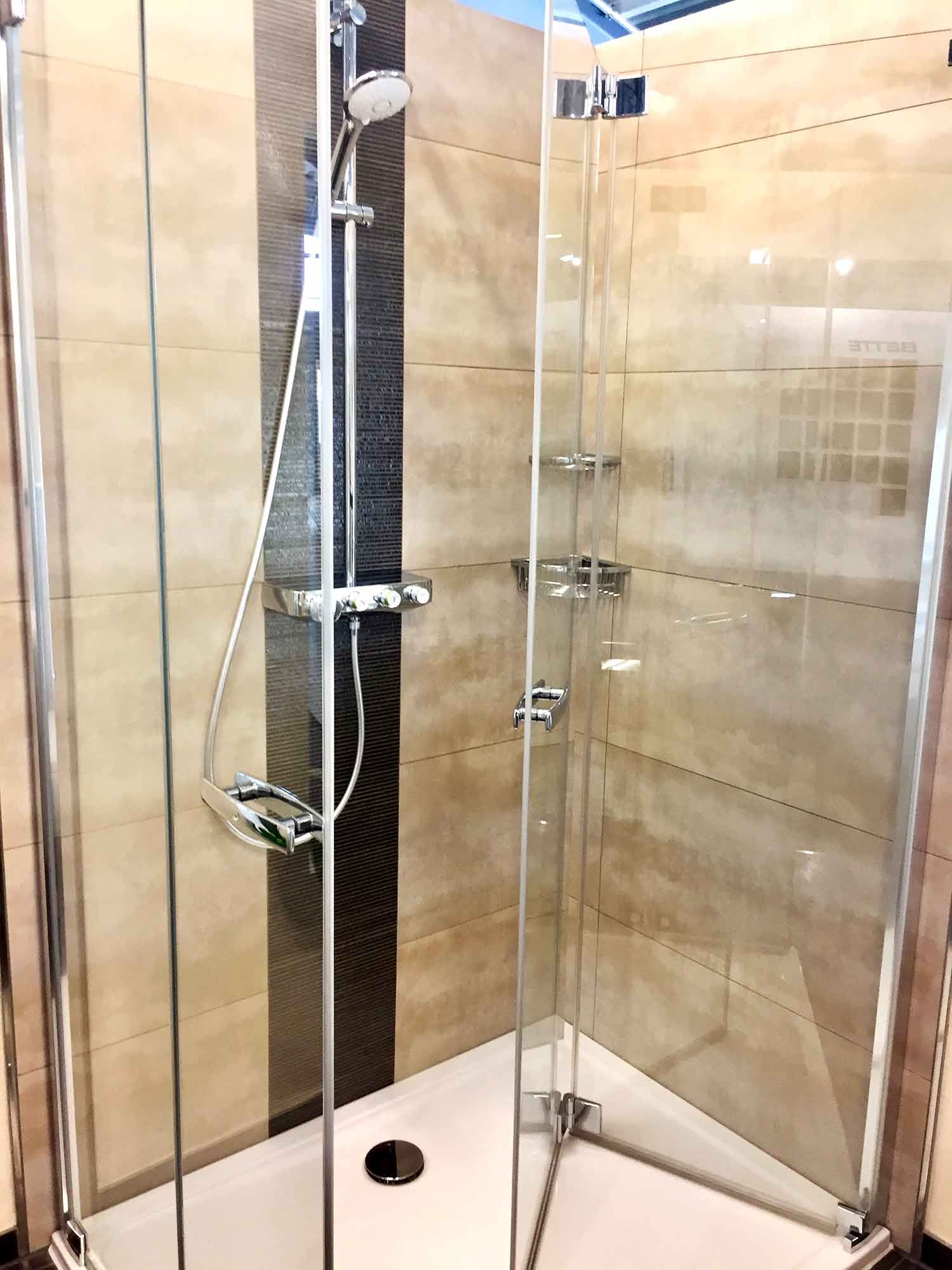 Eine Duschkabine mit Glasschiebetüren und Duschkopf.