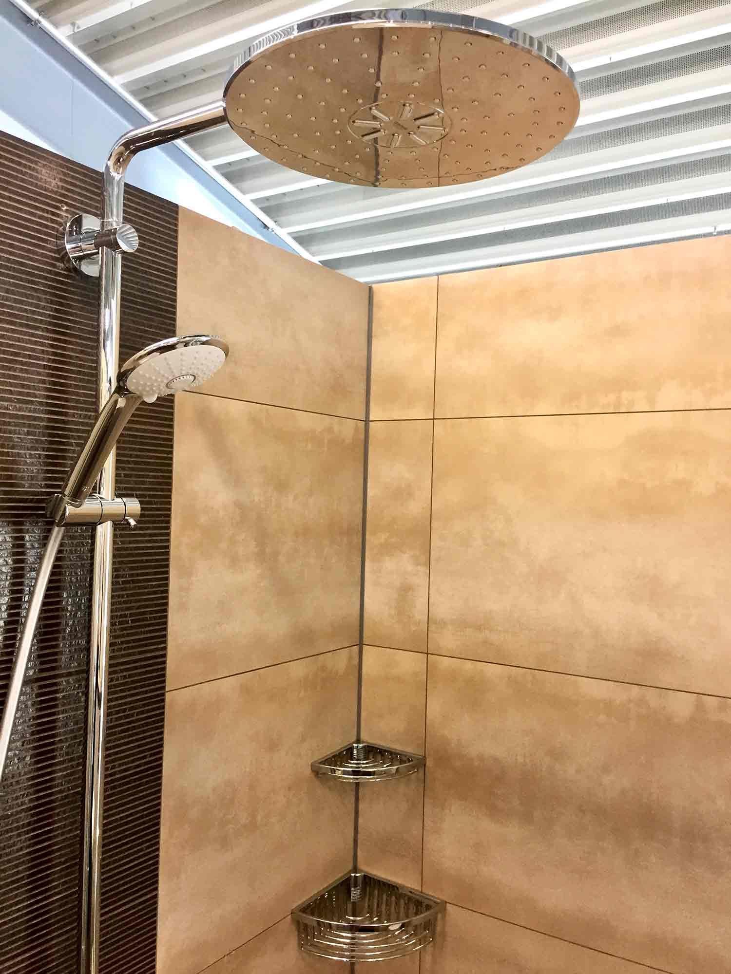 In einem Badezimmer hängt ein Duschkopf von der Decke.