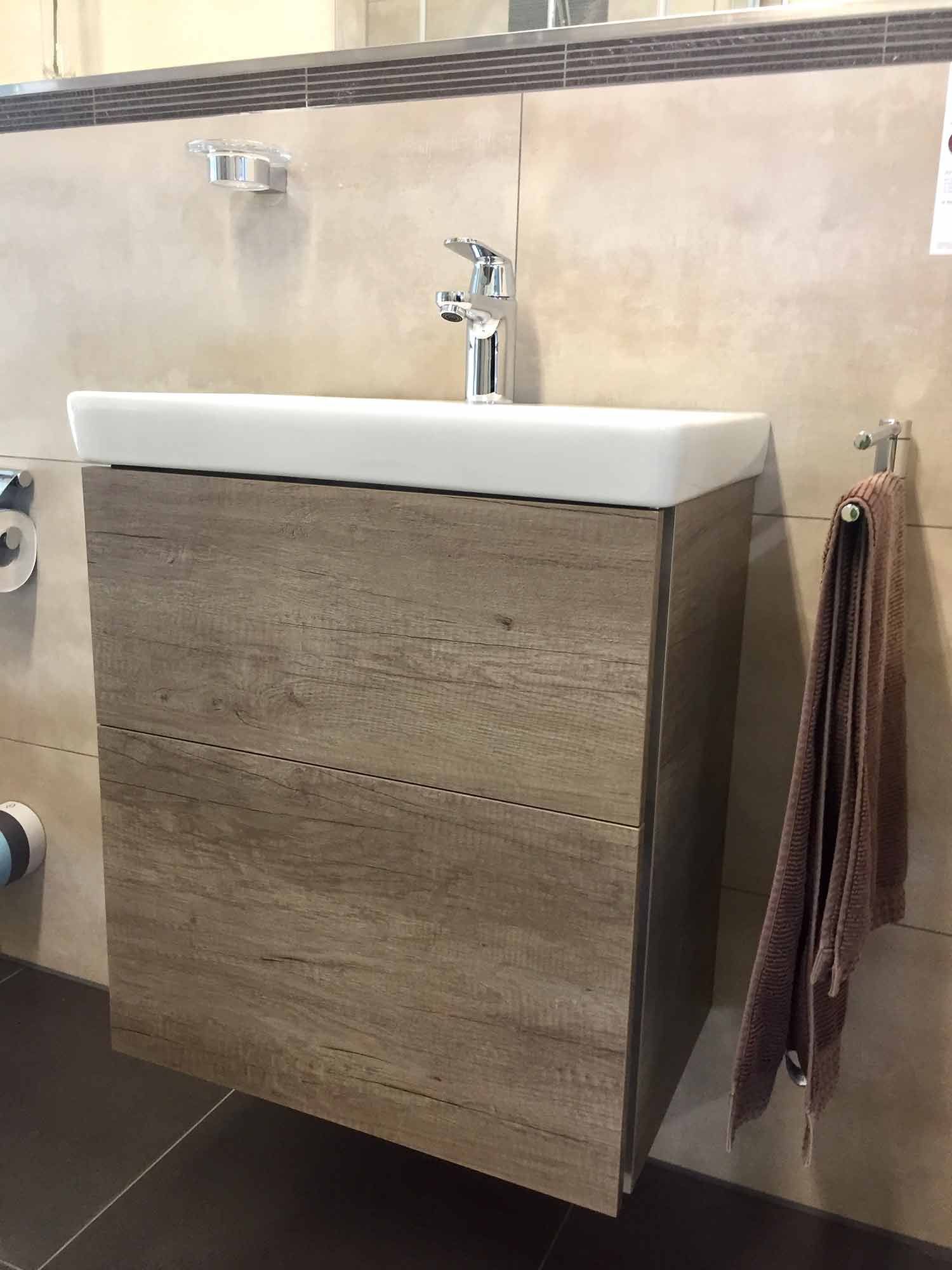 Ein Badezimmer mit einem Waschbecken und einem an der Wand hängenden Handtuch.