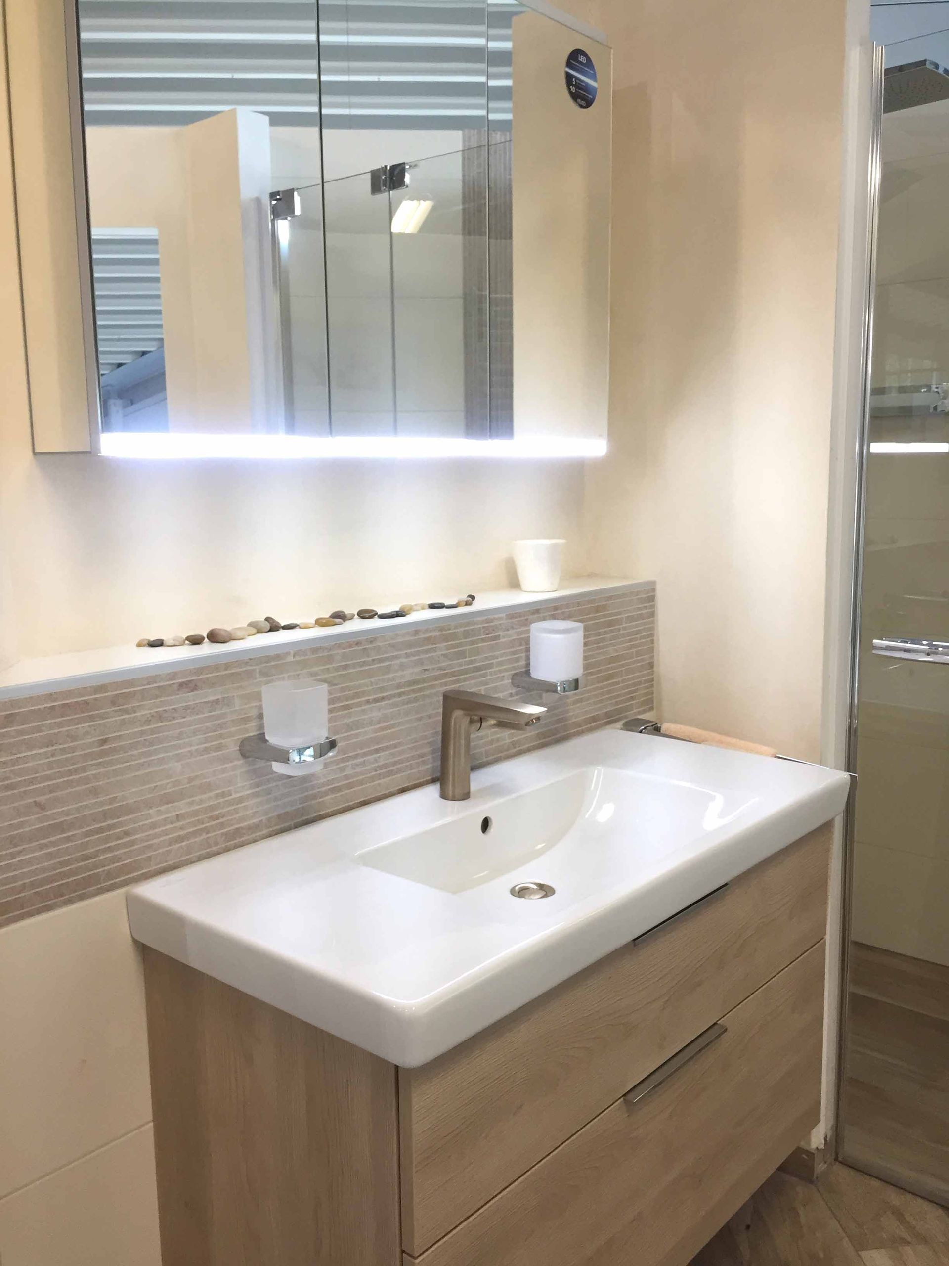 Ein Badezimmer mit einem Waschbecken und einem Spiegel darüber