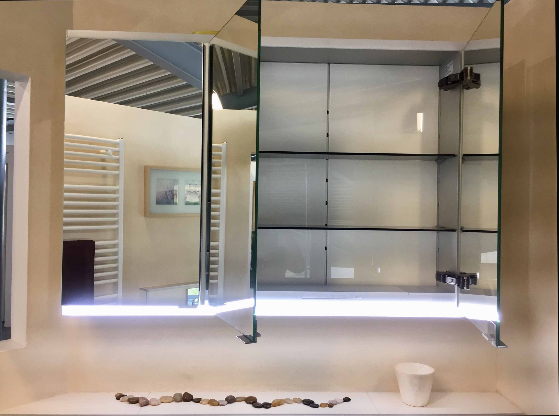 Ein Badezimmer mit großem Spiegel und Regalen