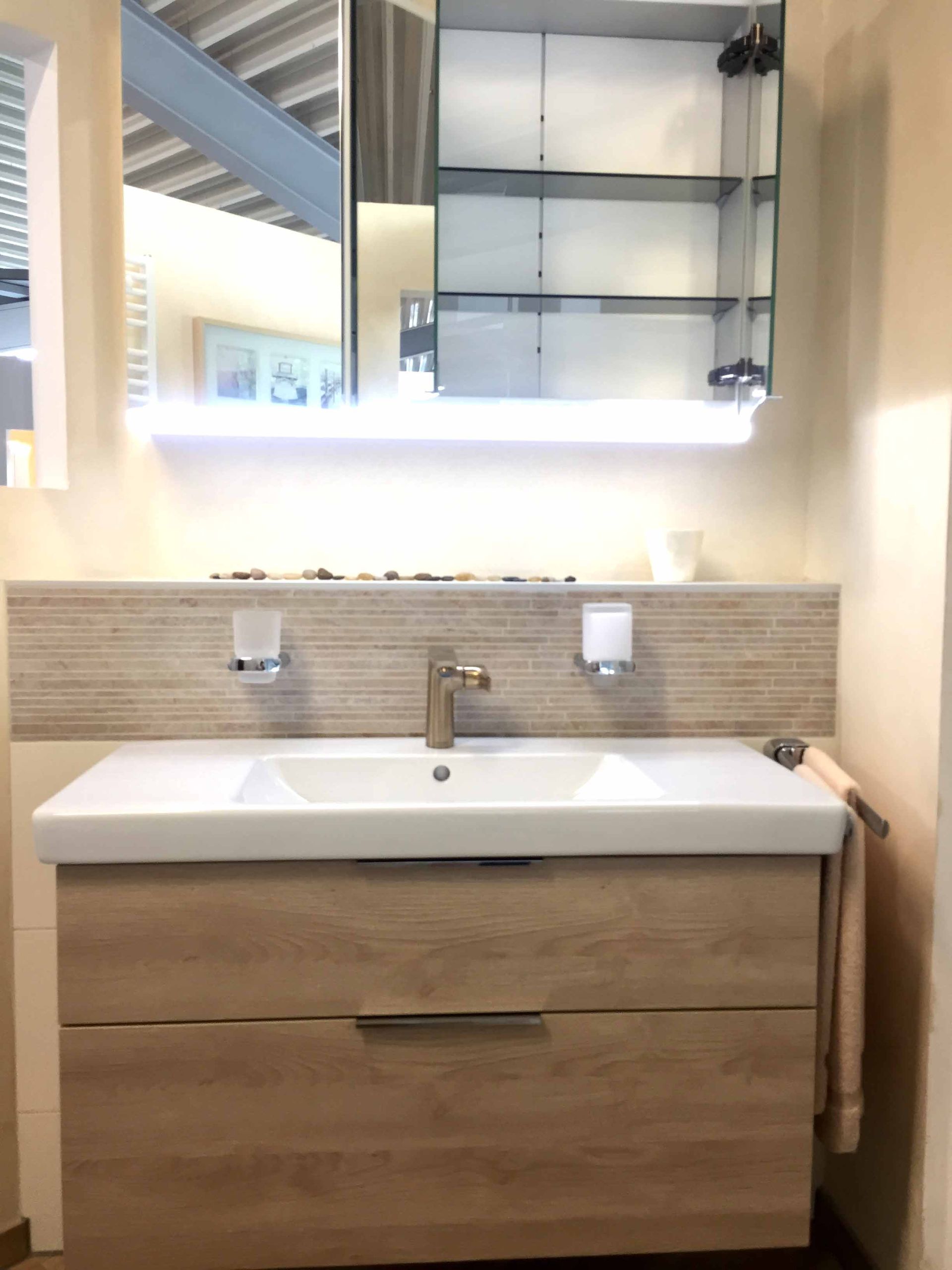 Ein Badezimmer mit einem Waschbecken und einem Spiegel darüber