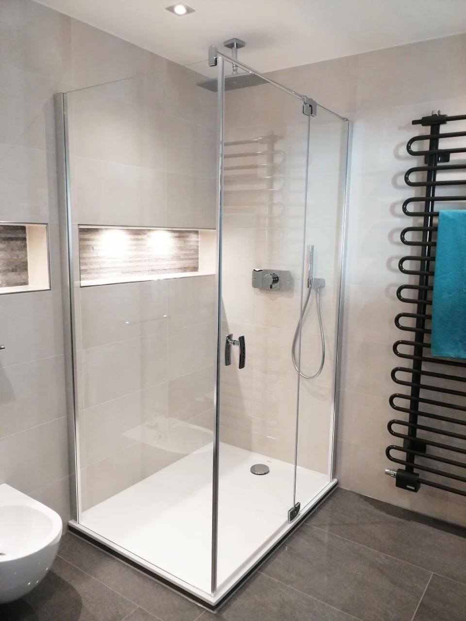 Ein Badezimmer mit ebenerdiger Dusche und Toilette