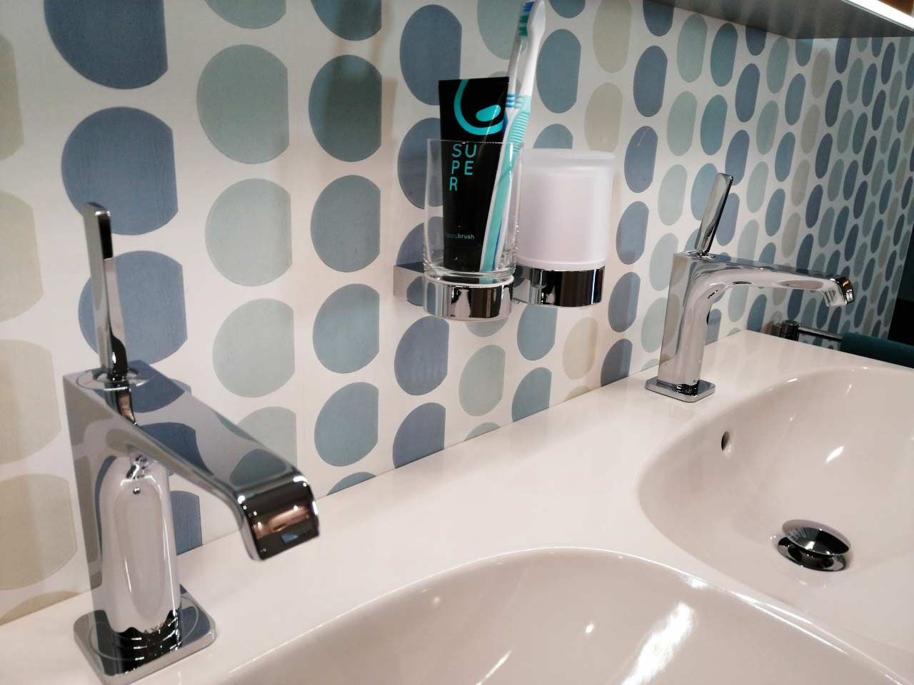 Ein Badezimmer mit zwei Waschbecken und einem Zahnbürstenhalter