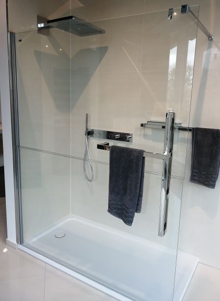 Eine ebenerdige Dusche mit Handtuchhalter und Duschkopf