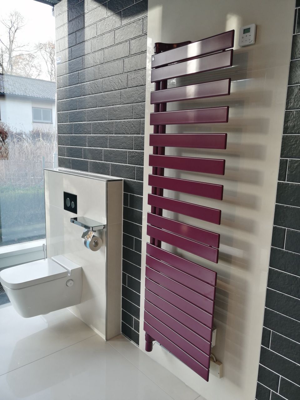 Ein Badezimmer mit einem lila Handtuchhalter und einer Toilette