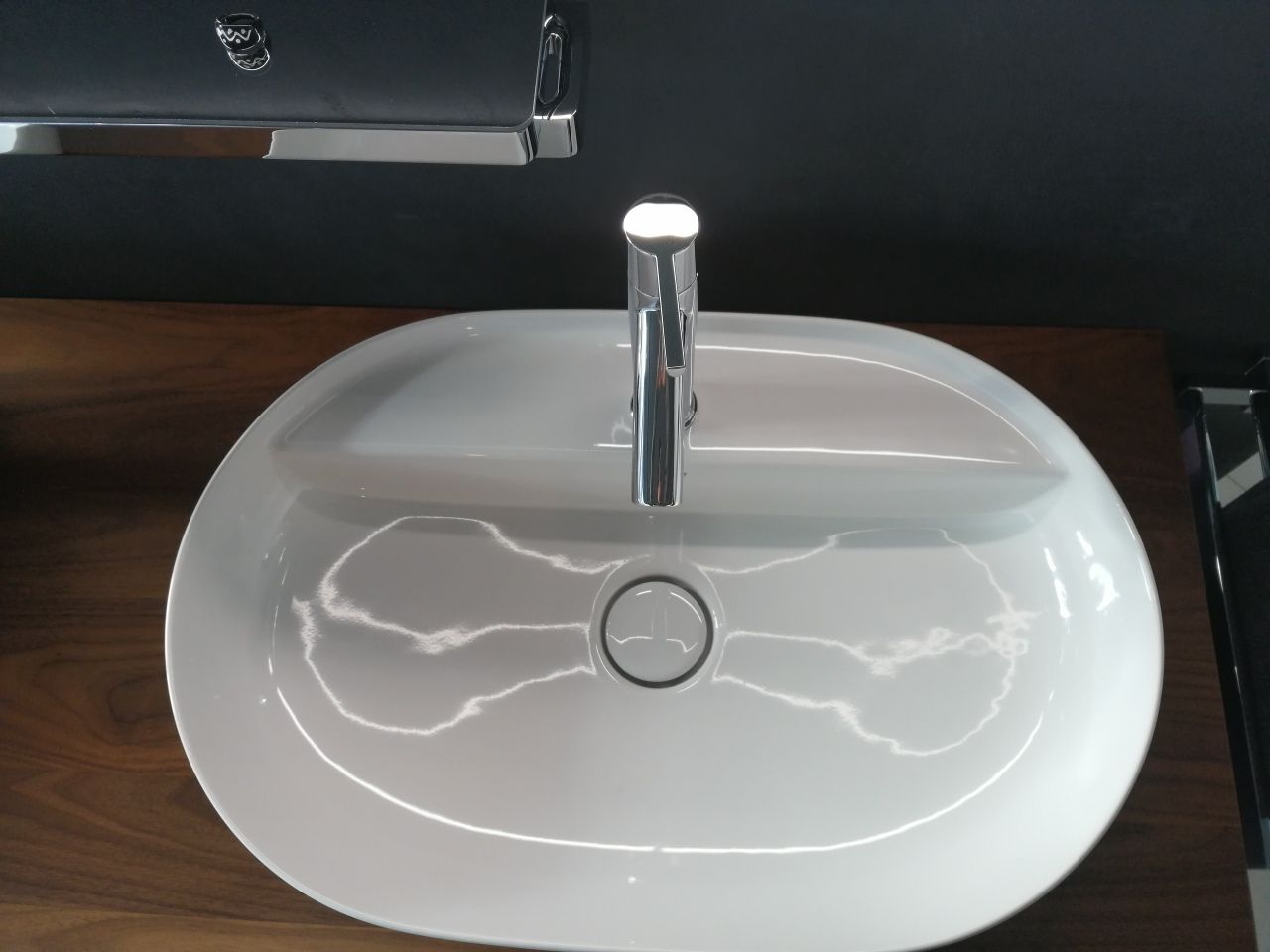 Ein weißes Waschbecken mit einem Chromhahn auf einer Holzarbeitsplatte