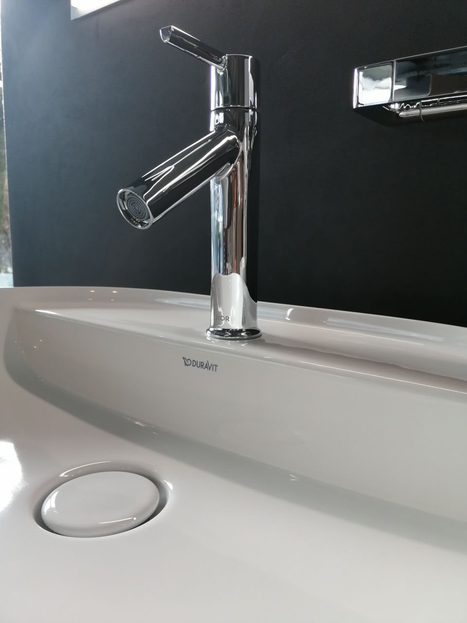 Eine Nahaufnahme eines Waschbeckens mit einem Chromhahn