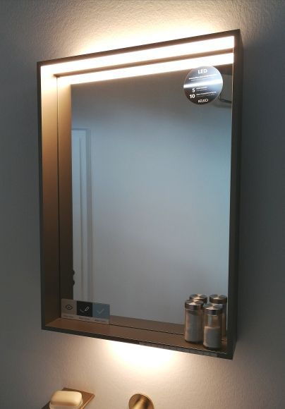 Ein Badezimmerspiegel mit einer Beleuchtung dahinter