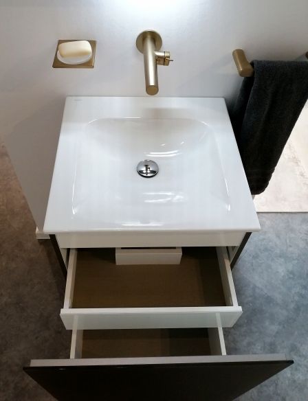 Ein Waschbecken mit einer offenen Schublade darunter