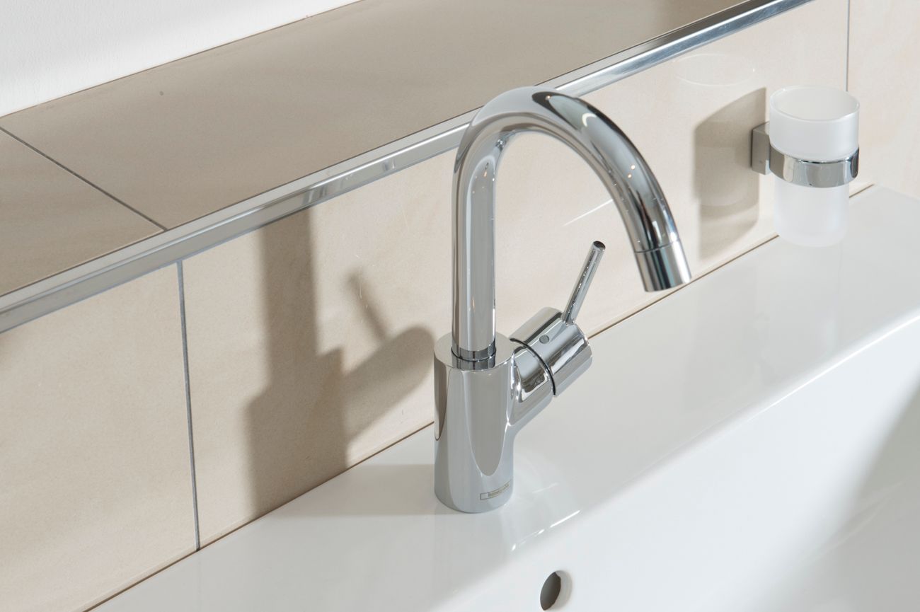 Eine Nahaufnahme eines Waschbeckens mit einem Chromhahn