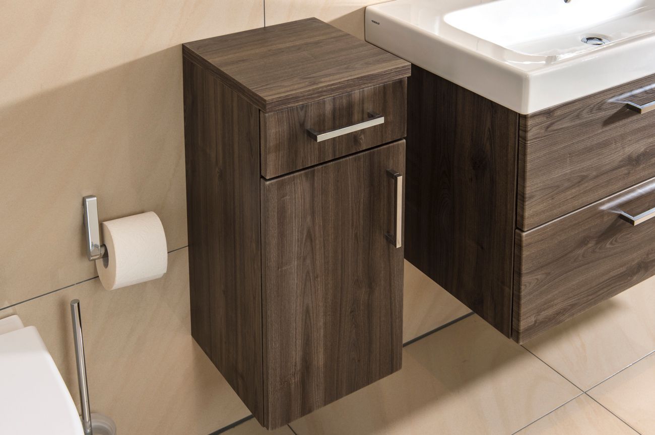 Ein Badezimmer mit Toilette, Waschbecken, Schrank und Toilettenpapierhalter.