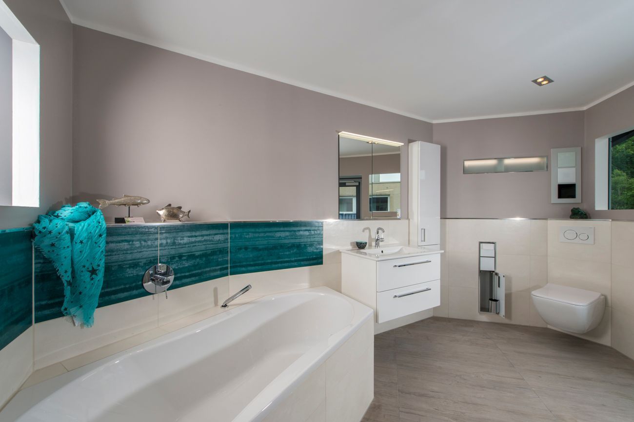 Ein Badezimmer mit Badewanne, Waschbecken, Toilette und Spiegel.