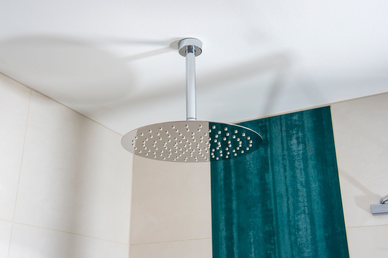 Ein Duschkopf hängt von der Decke in einem Badezimmer