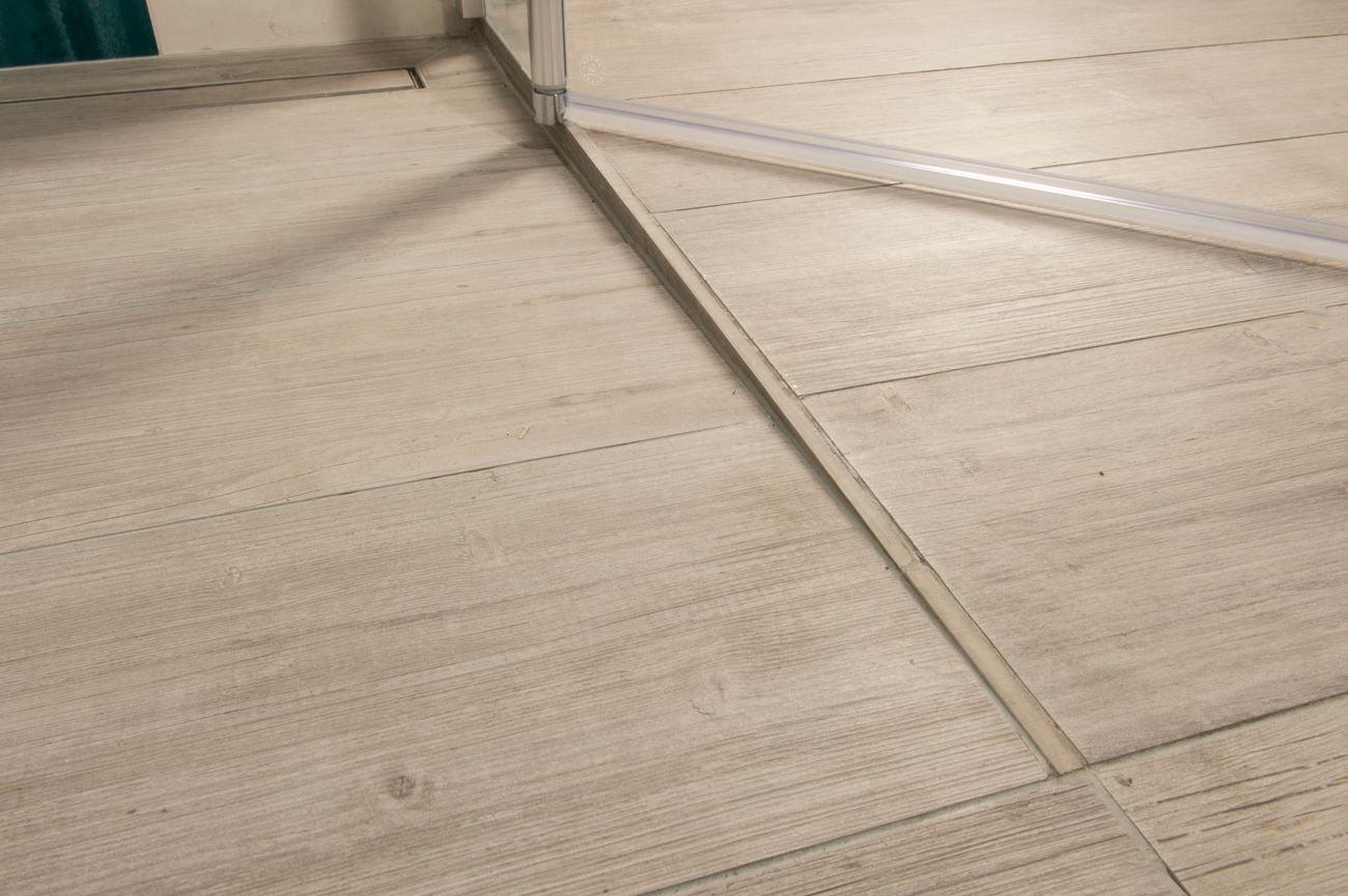 Eine Nahaufnahme eines Holzbodens mit einer Tür im Hintergrund.