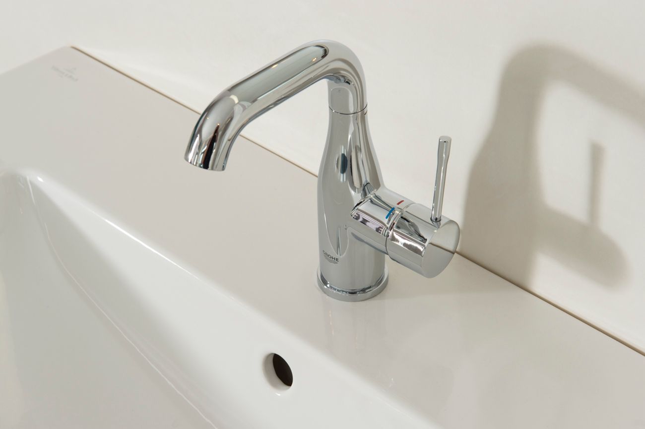 Eine Nahaufnahme eines Waschbeckens mit einem Chromhahn