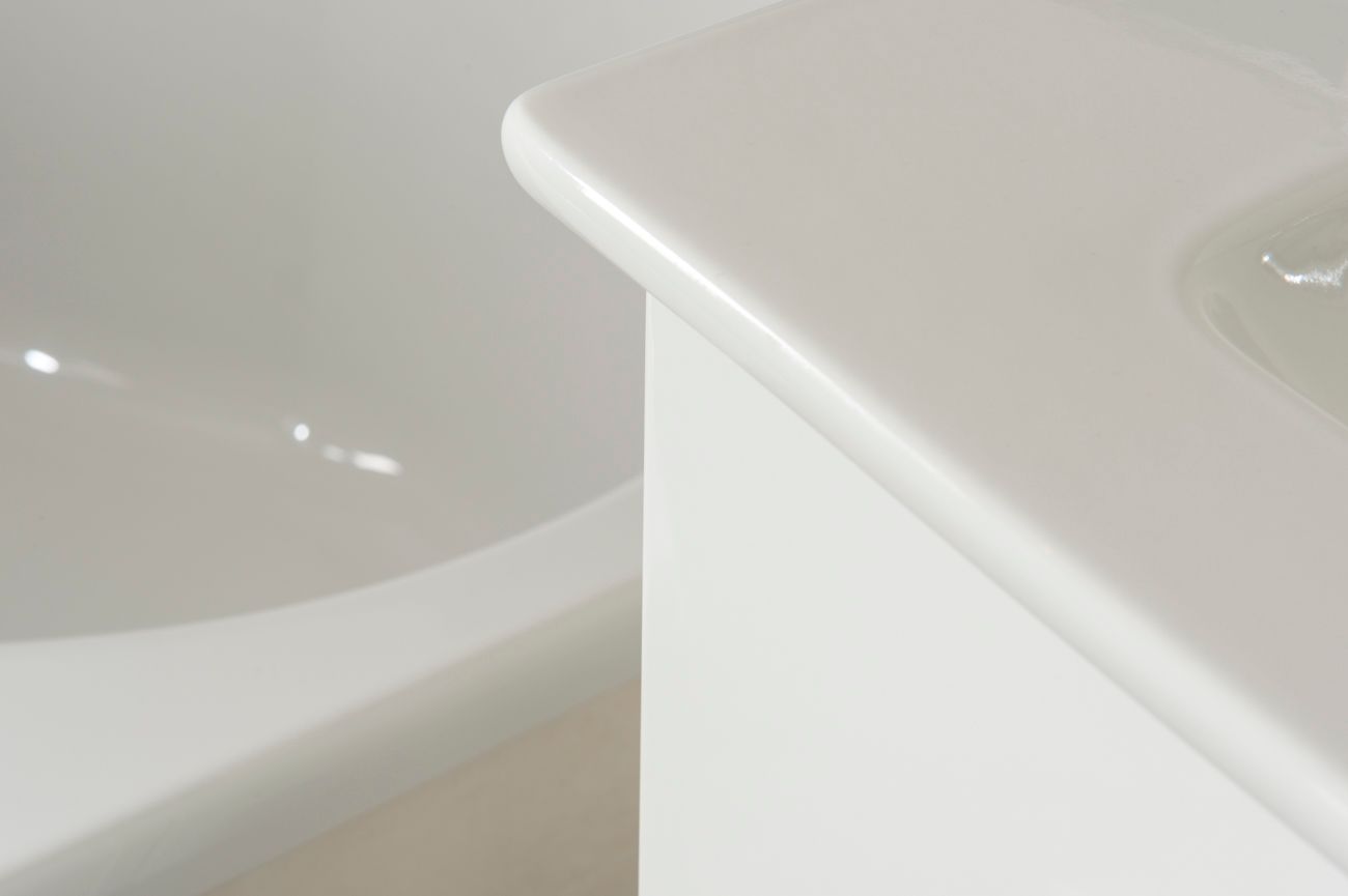 Eine Nahaufnahme eines weißen Waschbeckens und einer Badewanne in einem Badezimmer.