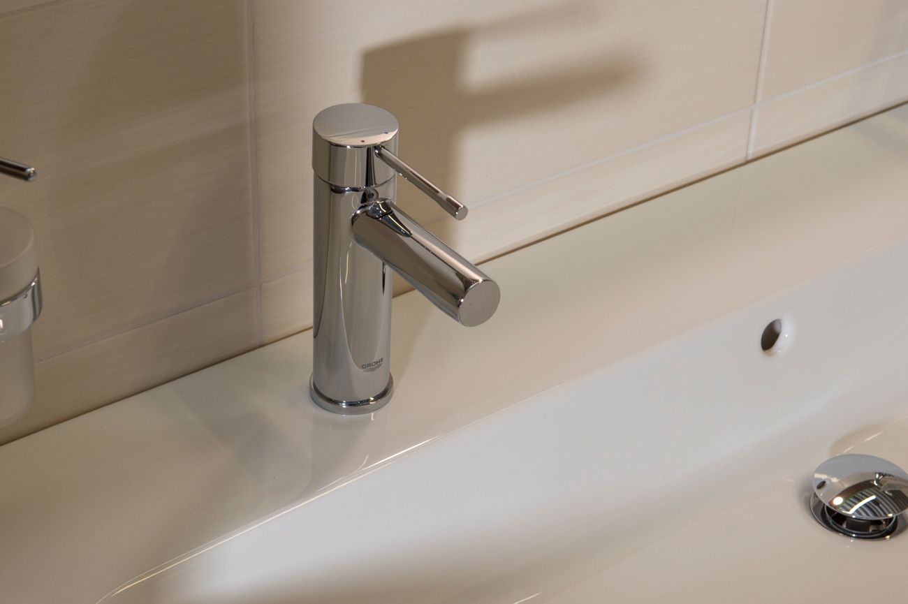 Eine Nahaufnahme eines Waschbeckens mit einem Chromhahn.