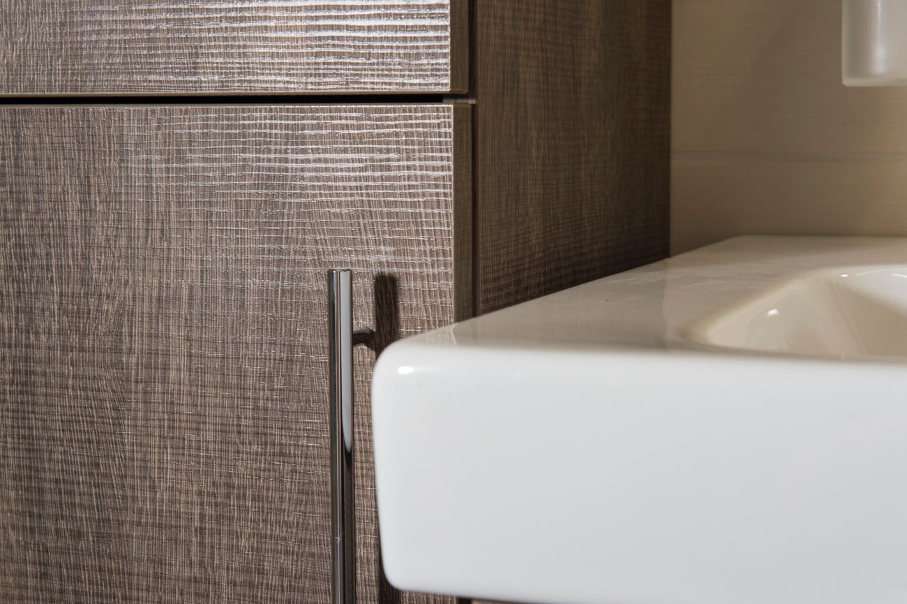 Ein Waschbecken mit einem Holzschrank daneben.