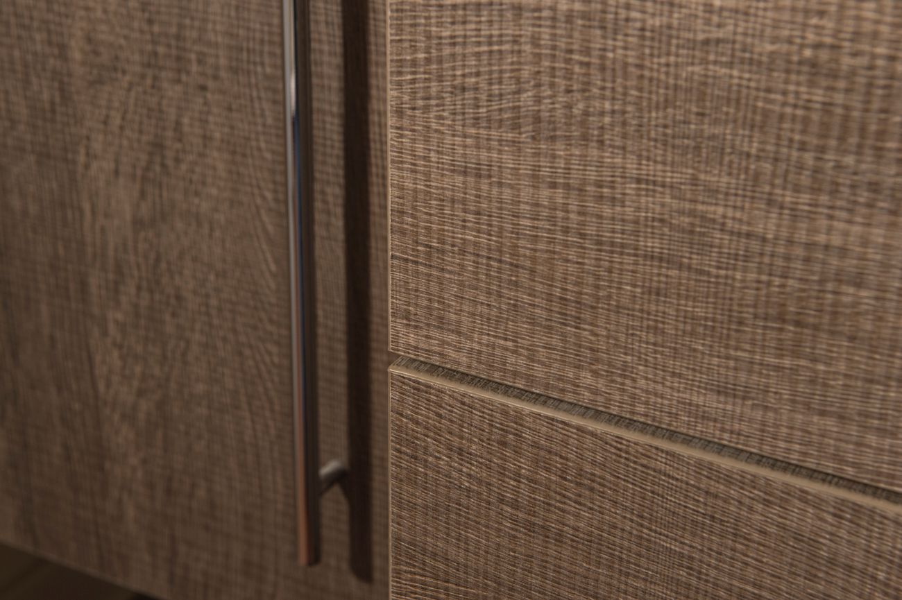 Eine Nahaufnahme eines Holzschranks mit einem Metallgriff.