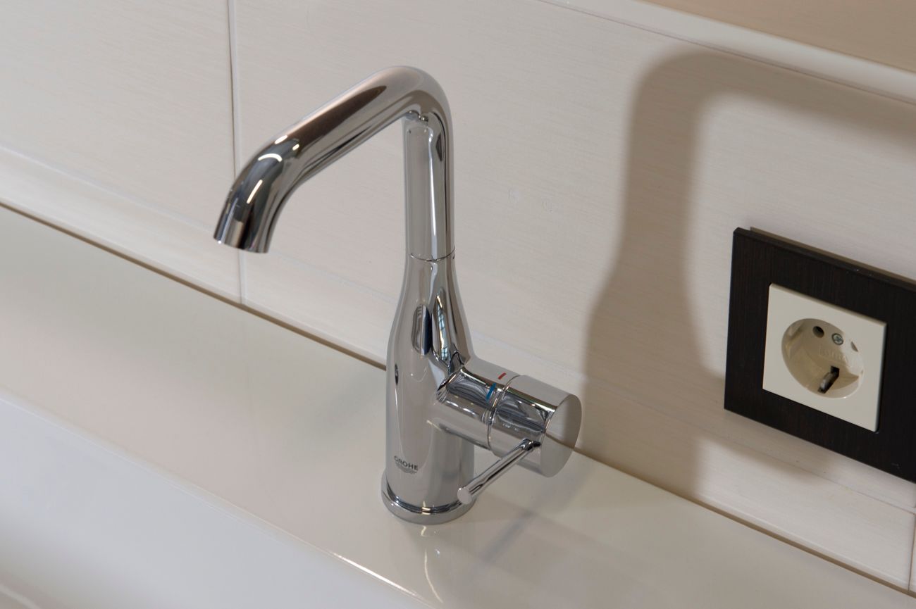 Ein Waschbecken mit Wasserhahn und Steckdose
