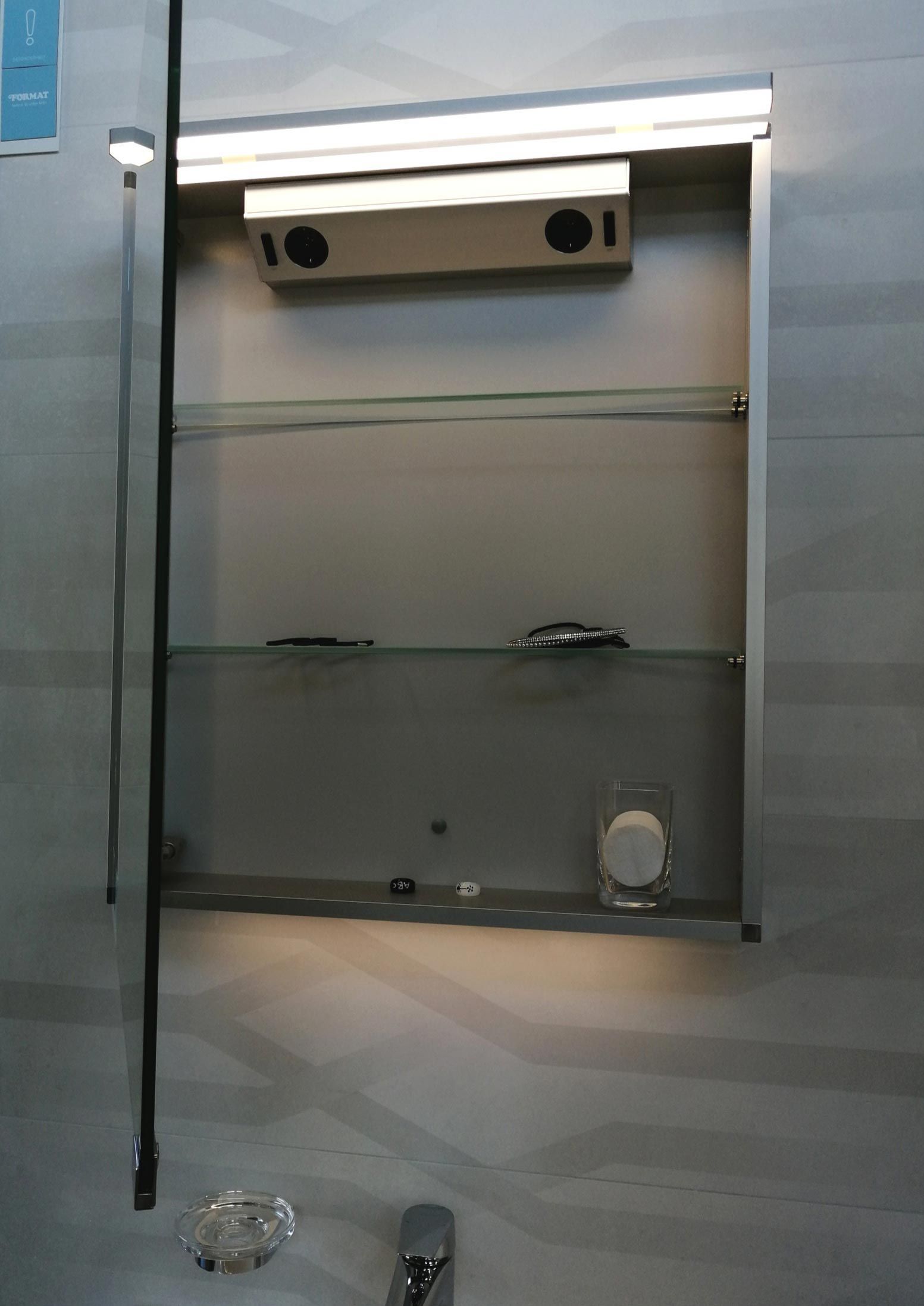 Ein Badezimmer-Medizinschrank mit einer Lampe darauf