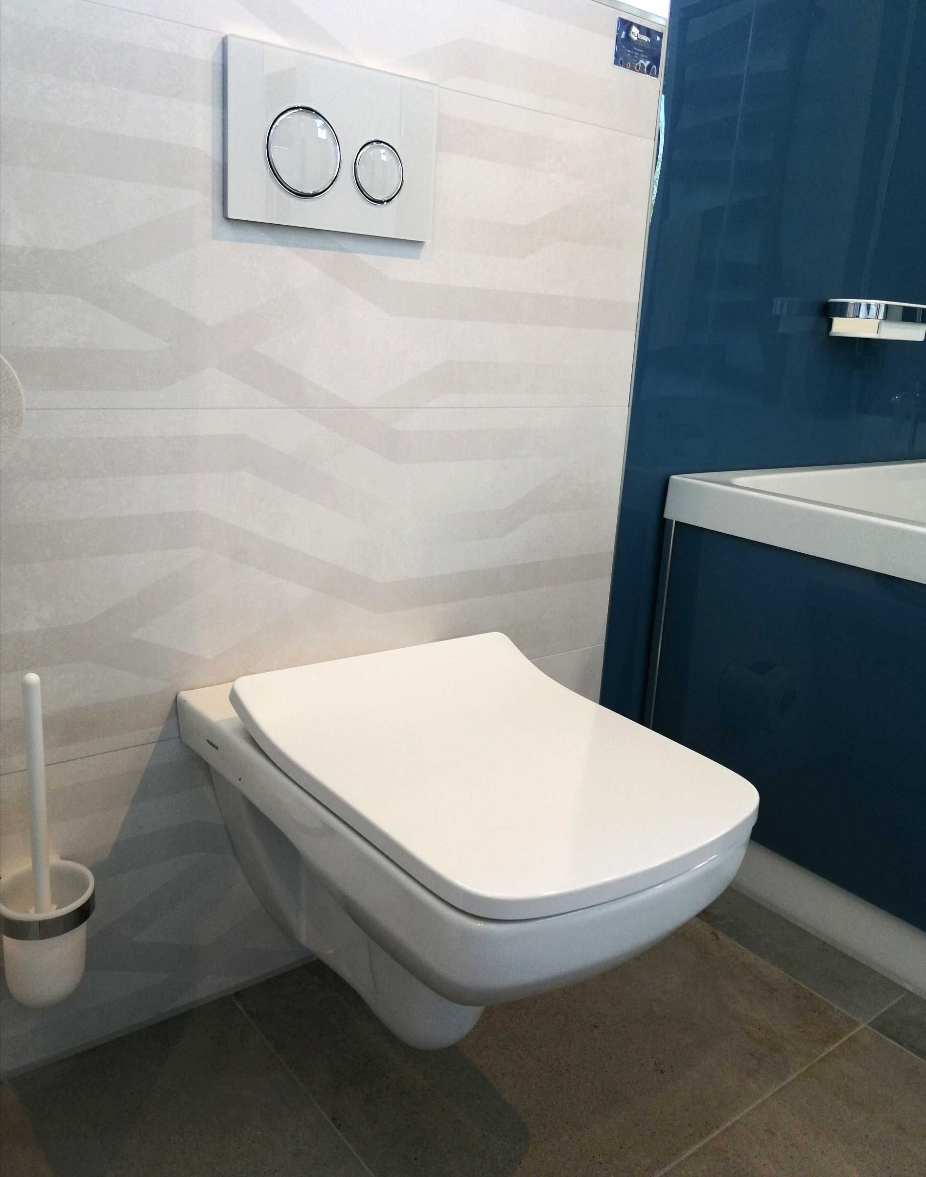 Ein Badezimmer mit einer weißen Toilette und einer blauen Wand