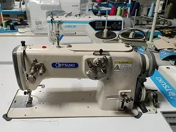 Una máquina de coser está sobre una mesa en una fábrica.