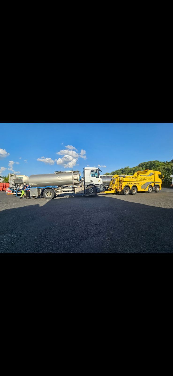 Camion jaune de l'entreprise Garage Gauthier devant un camion citerne