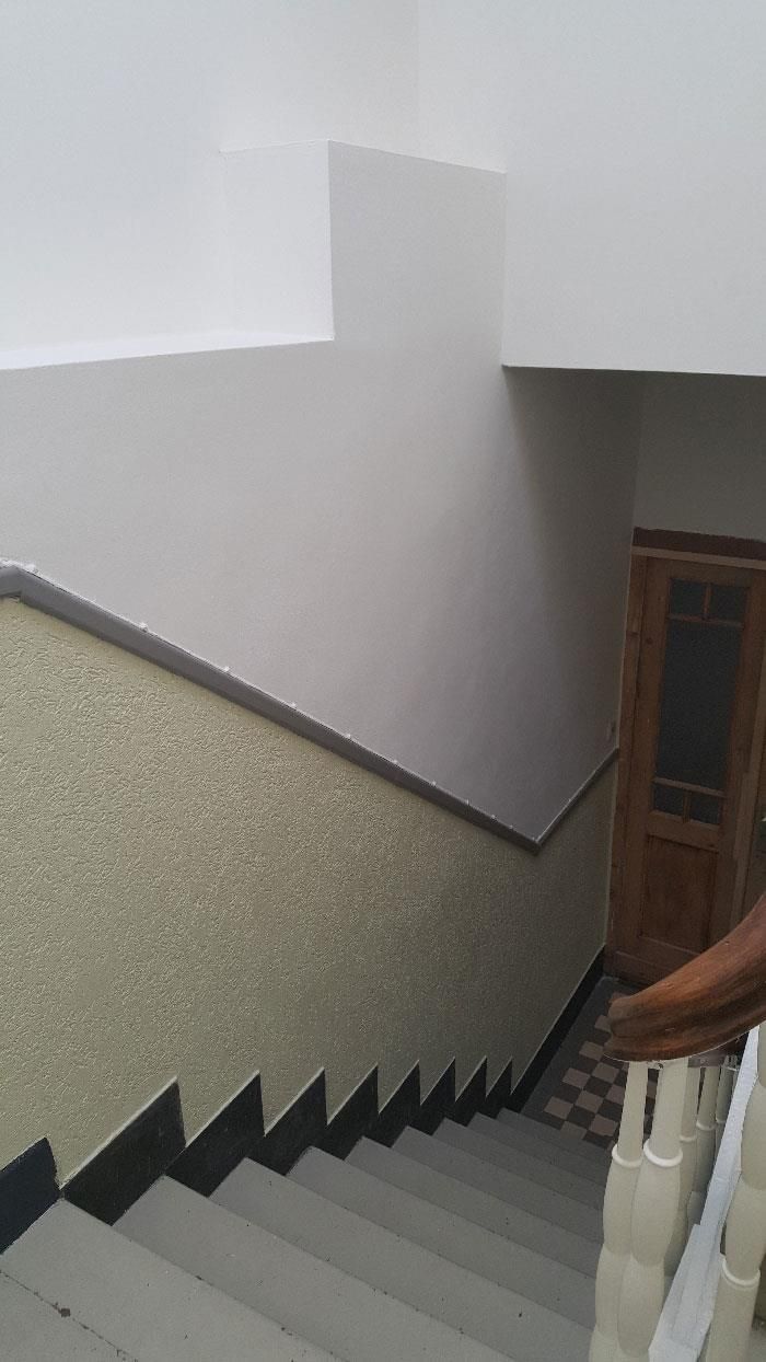 Eine Person geht in einem Gebäude eine Treppe hinunter.